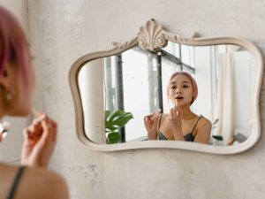 Women doing her makeup in front of a mirror
