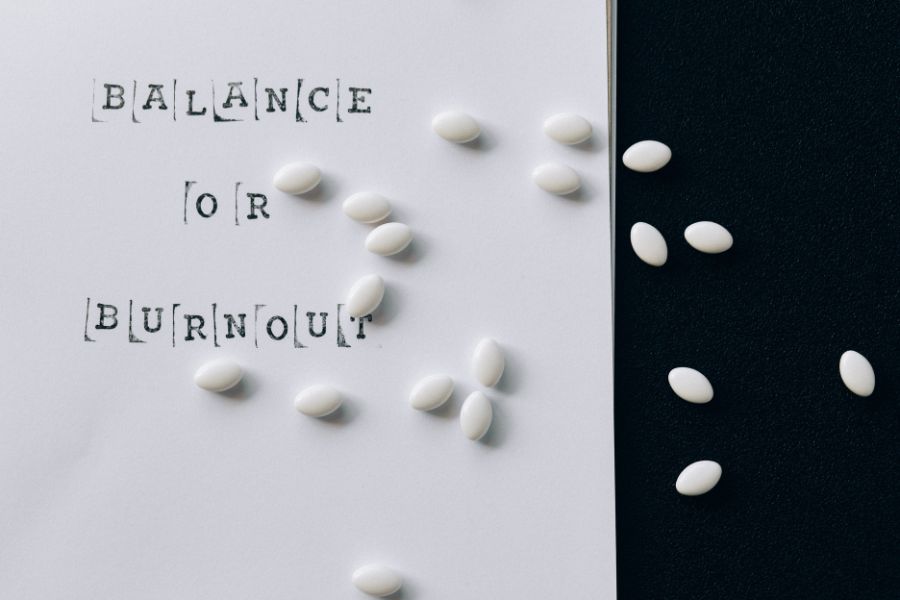 Balance and burnout paper on the dask with pills