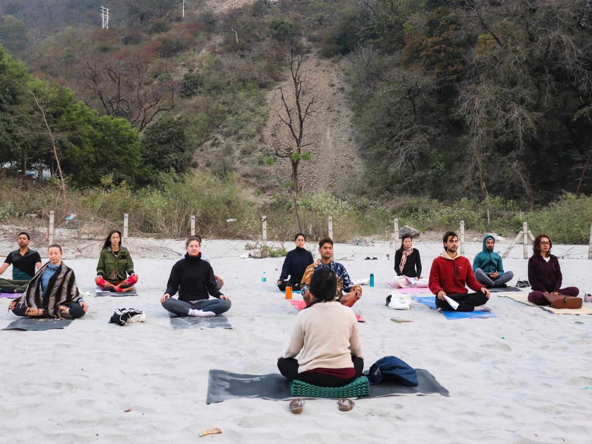 Group of people meditating on the beach